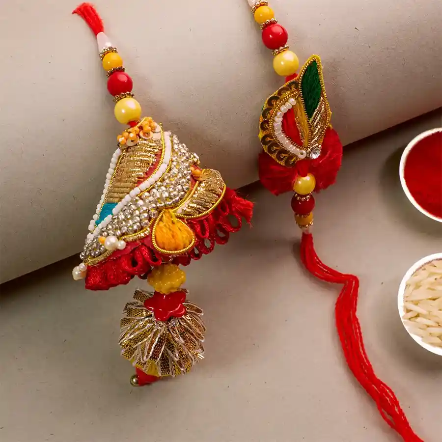 Designer Bhaiya Bhabhi Rakhi Set featuring a stylish Rakhi, vibrant roli, traditional tilak, and sweet chawal, celebrating the bond of love and family.