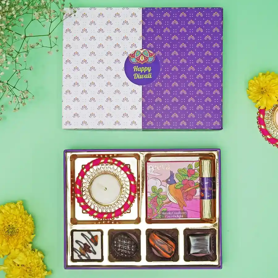 Chocolate Gala Gift Box featuring an assortment of fruity, nutty, and citrusy chocolates, a Masala Cranberry Coco bar, a Fruit & Nut Log, and a handcrafted Diya for Diwali celebration.