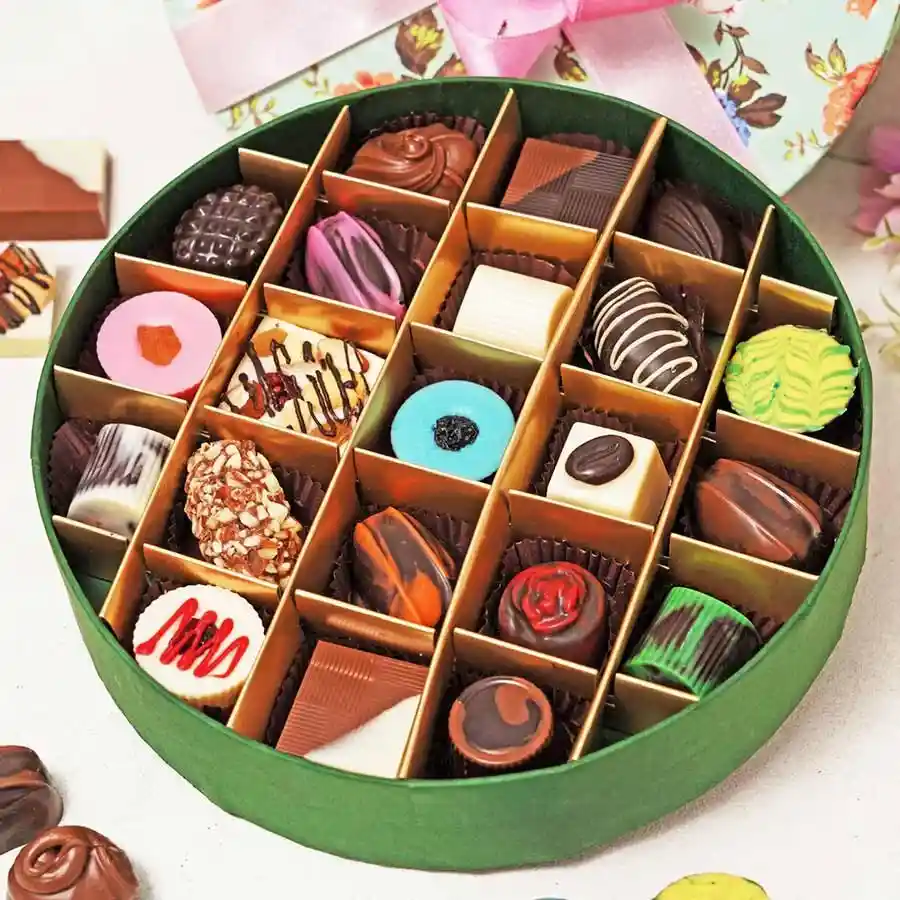 A beautifully arranged gift box filled with 21 assorted chocolates including dark, milk, and flavored varieties like Almond Rock, Strawberry Soft Filled, and Cranberry Hazelnut.
