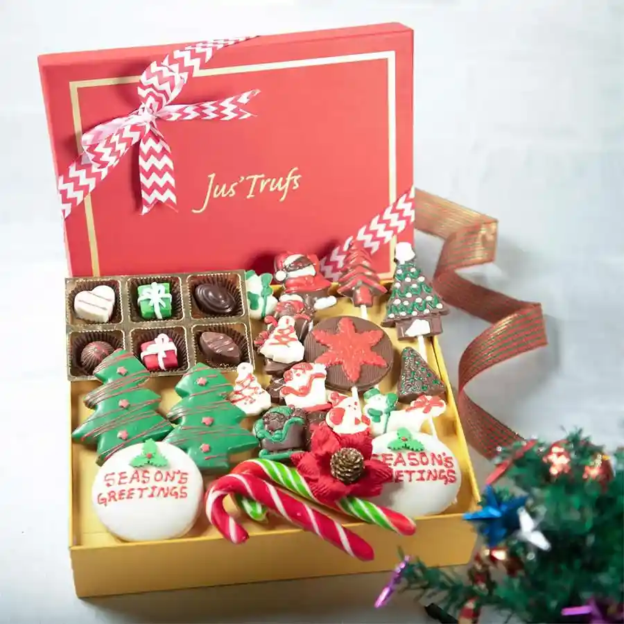 A beautifully arranged holiday sweet celebration basket filled with chocolate-coated cookies, truffles, festive chocolate shapes, lollipops, and candy canes.
