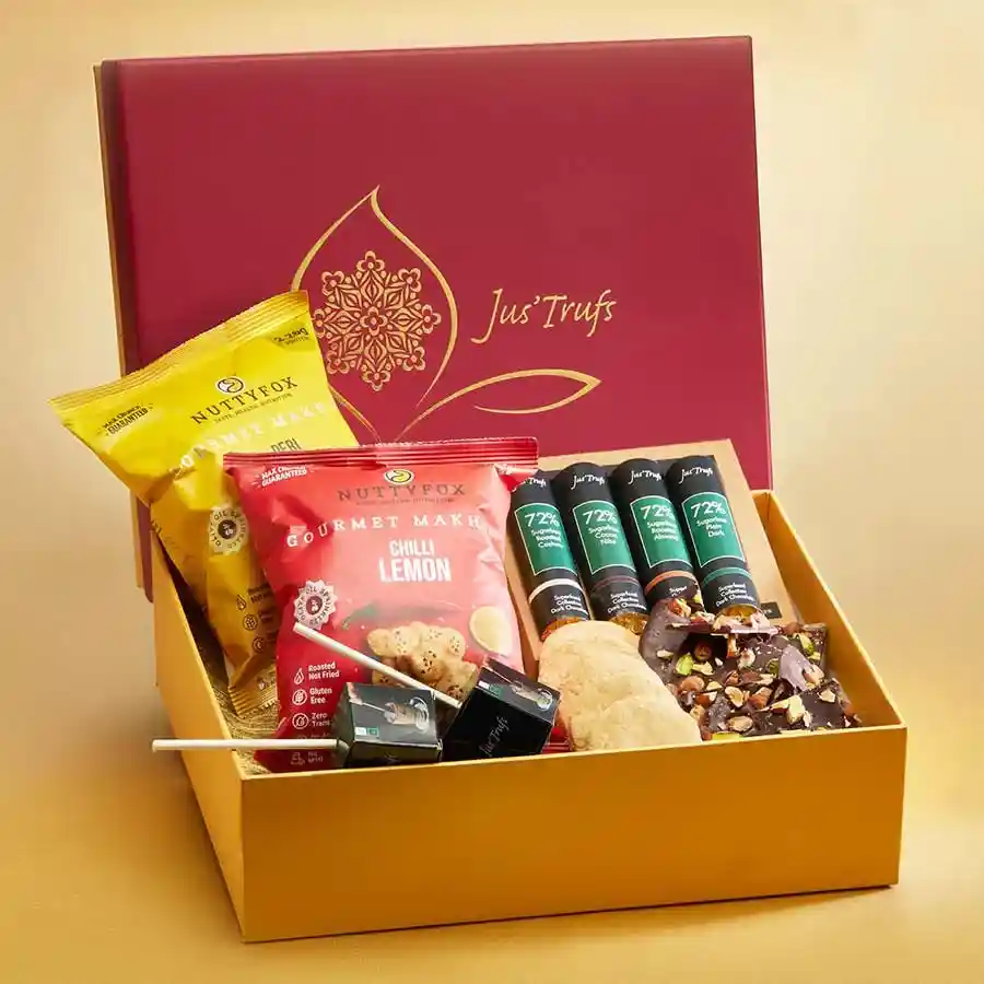 Sugar Free Snacking Essentials box featuring Superfood Chocolate Logs, Chok Hot with Cinnamon mix, 72% dark Chocolate Barks with pistachios, Salt and Chili Cookies, and crunchy Makhana.
