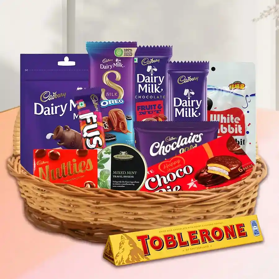 Chocolate gift basket filled with Cadbury Dairy Milk, Toblerone, Silk Oreo, and Lotte Chocopie, elegantly presented with a red ribbon.