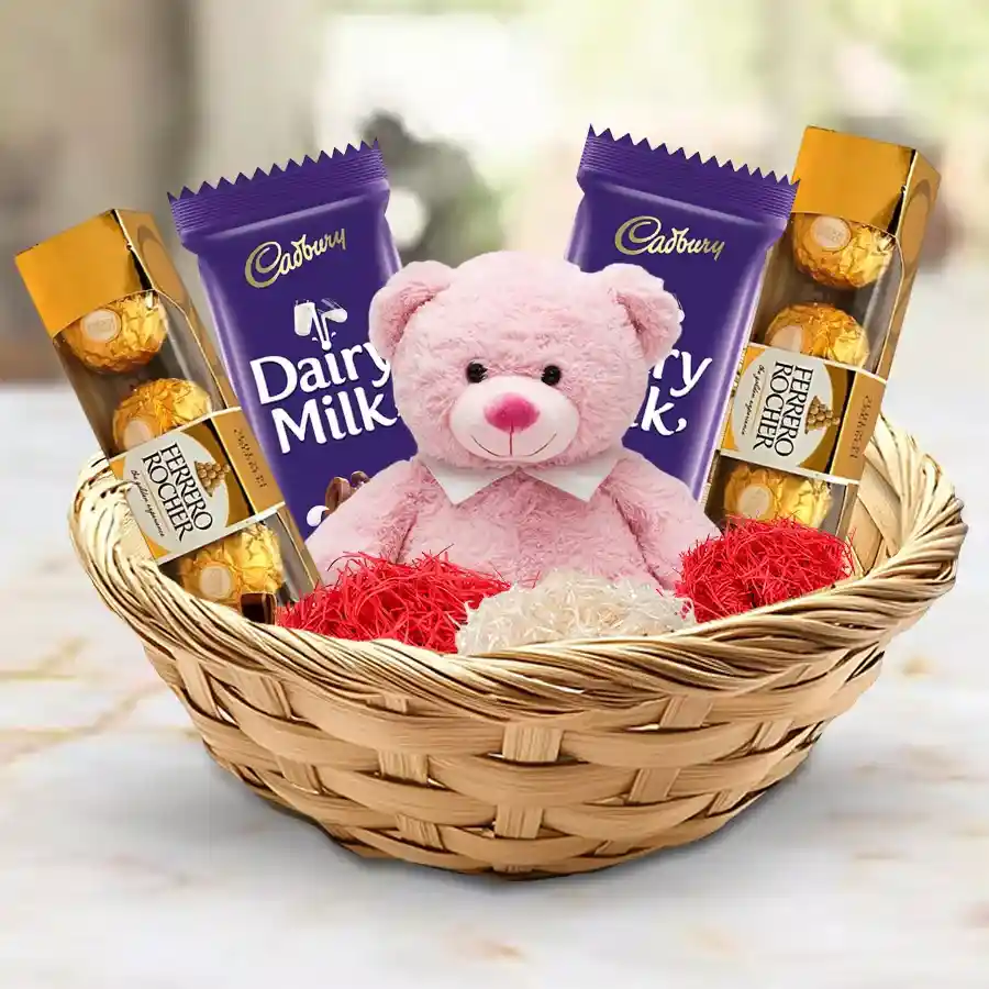 Exquisite basket featuring an adorable teddy bear with an "I Love You" message, two packs of Ferrero Rocher chocolates, and two Cadbury Dairy Milk chocolate bars, all beautifully arranged