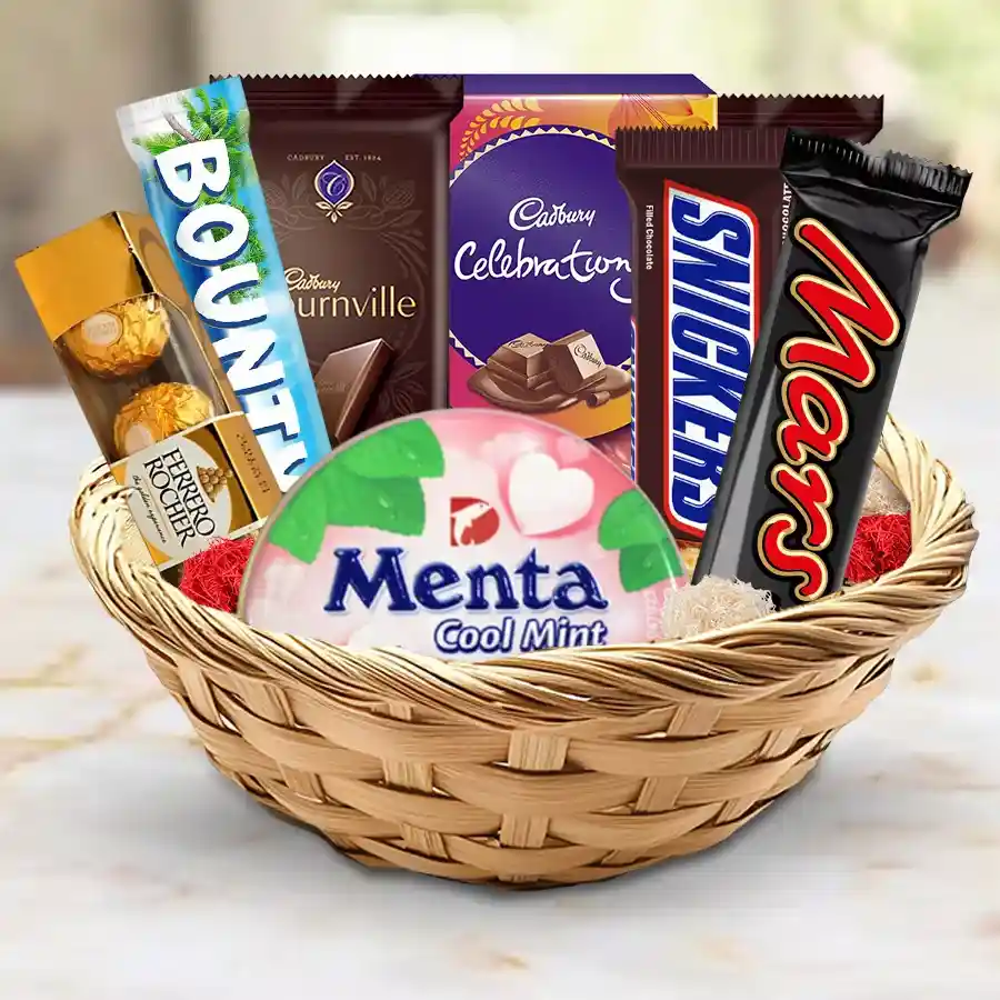 A beautifully arranged gift basket filled with a variety of exclusive chocolates including Mars Bar, Snickers, Ferrero Rocher, Bounty Coconut Milk, Cadbury Bournville, Cadbury Celebrations Minis, and Menta Cool Mint Chocolates.