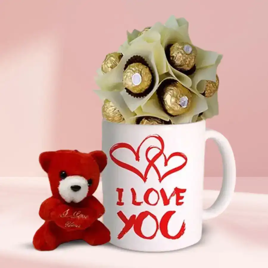 Teddy bear, personalized coffee mug with "I Love You" text, and Ferrero Rocher chocolates arranged as a gift set