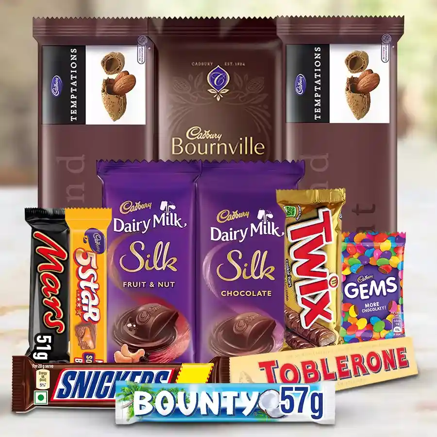 An assortment of premium chocolates including Cadbury Dairy Milk, Bournville, Twix, and Snickers arranged in an elegant hamper.