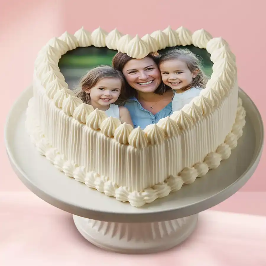 Heart-shaped eggless vanilla photo cake featuring a custom image on top, elegantly covered in white fondant.