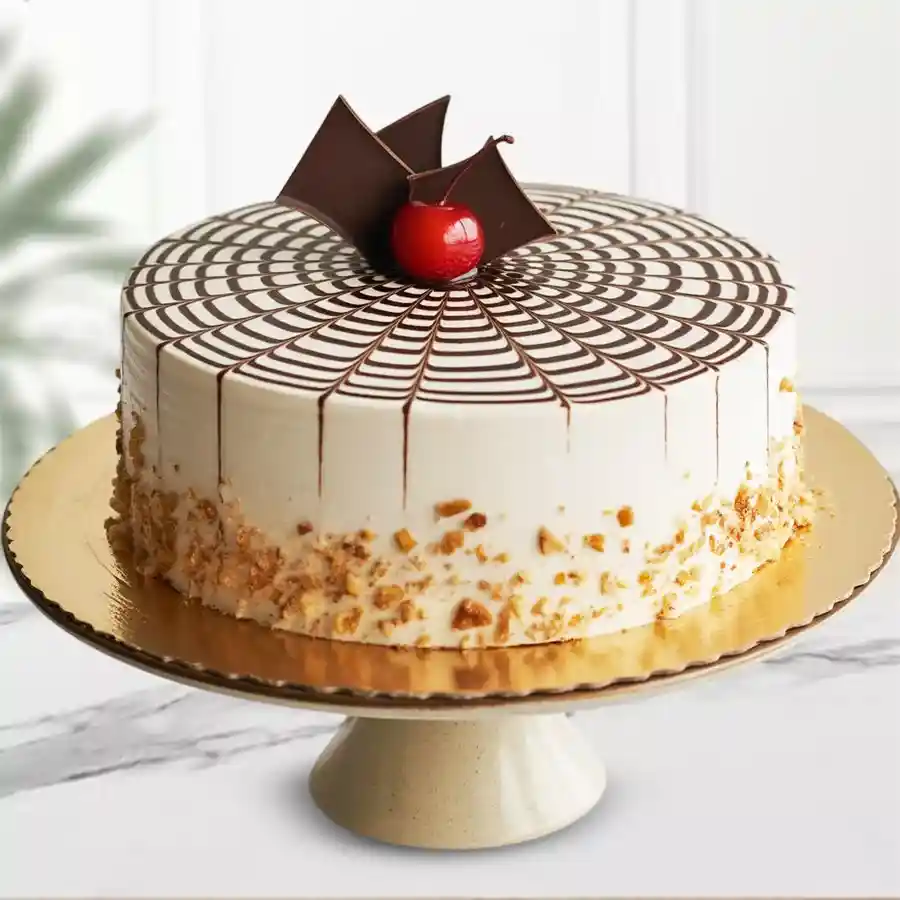 A scrumptious Butterscotch Cherry Delight Cake featuring a chocolate swirl topping and a cherry on top, perfect for celebrations.