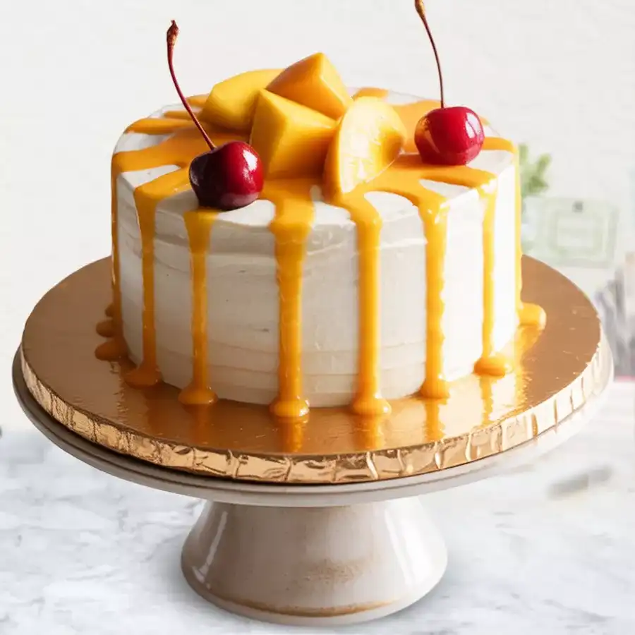 Irresistible Mango Cream Cake Delight with mango chunks and cherry on top, featuring a vanilla sponge base and fresh white cream frosting.