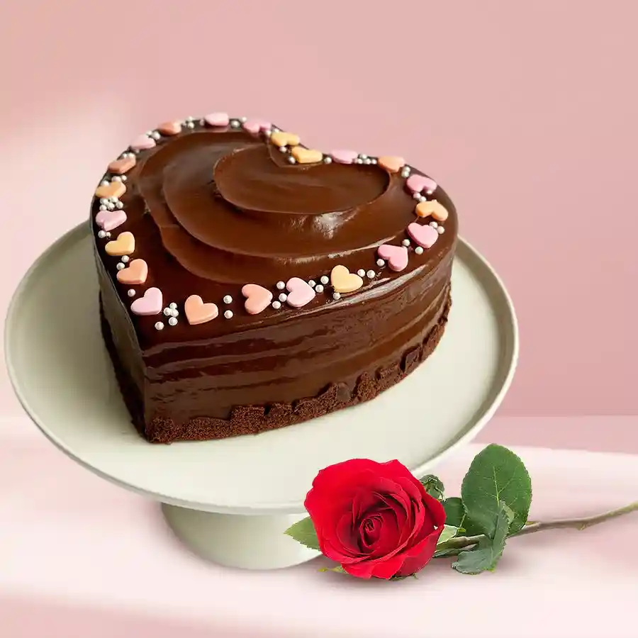 Heart-shaped chocolate cake with a red rose, perfect for expressing love.