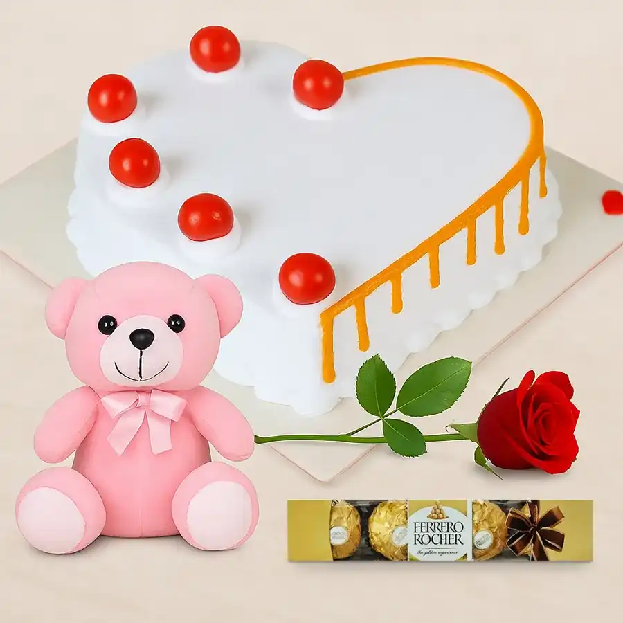 A heart-shaped vanilla cake with roses, teddy bear, and Ferrero Rocher chocolates, perfect for expressing love and affection.