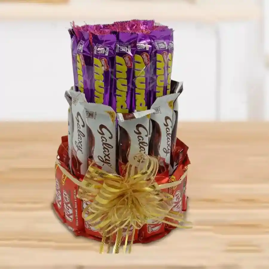 Classic 3-layer tower arrangement of mixed chocolates including Kit Kat, Galaxy bars, and Munch Wafers