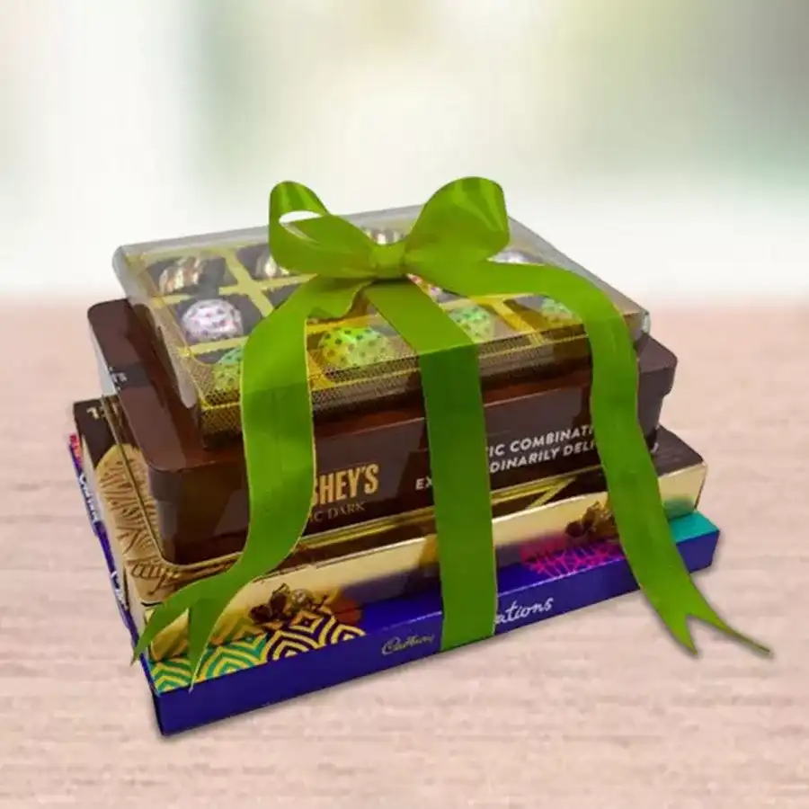 Chocolate tower gift featuring Ferrero Rocher Moments, Hershey's Kisses Exotic Dark Chocolate-covered fruits, Cadbury Celebration assorted chocolates, and handmade delights.
