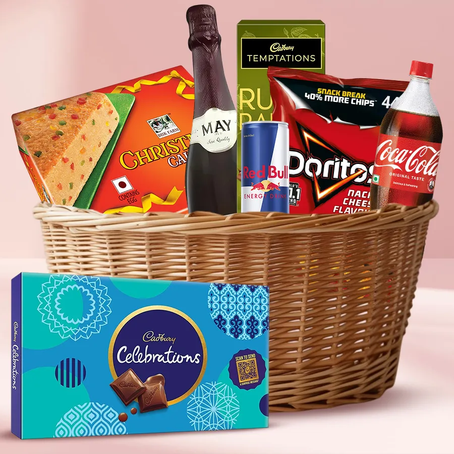 Festive gift basket featuring sparkling wine, chocolates, nachos, and a Christmas fruit cake.
