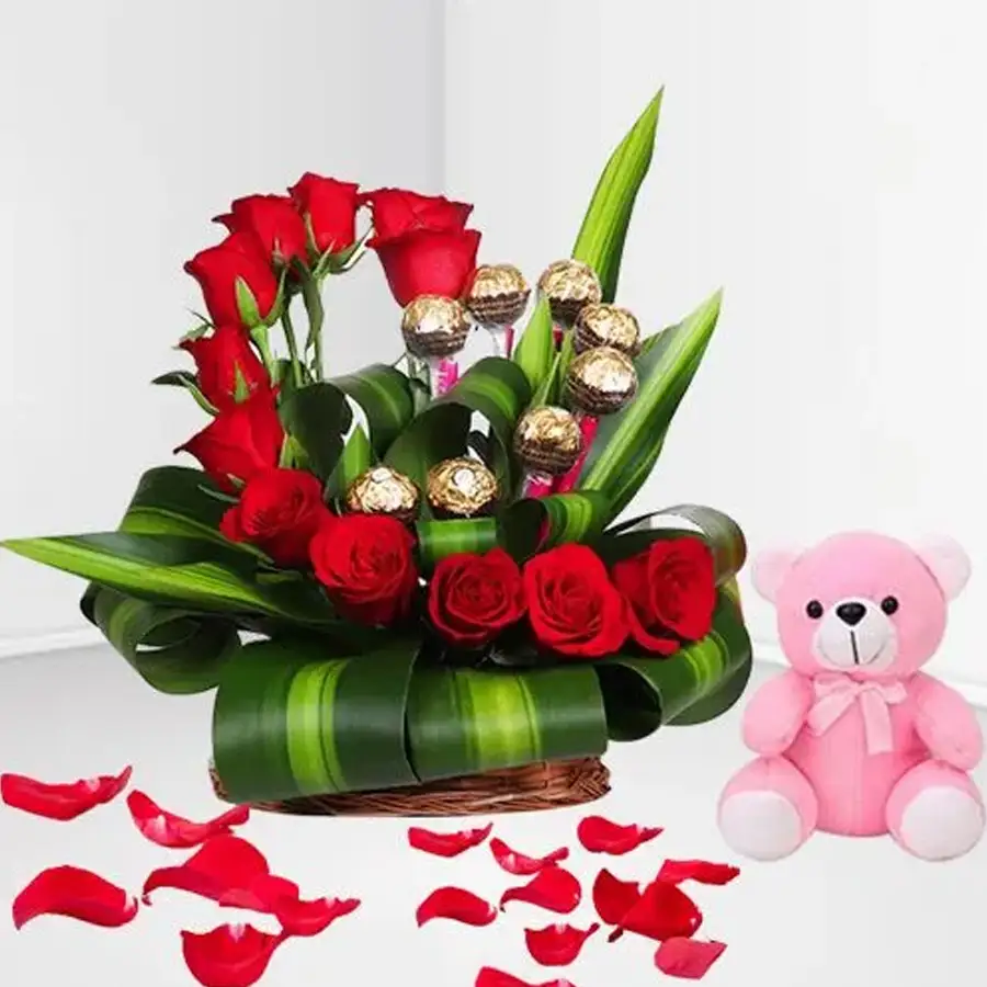 Heart-shaped arrangement of red roses and Ferrero Rocher with a teddy bear.