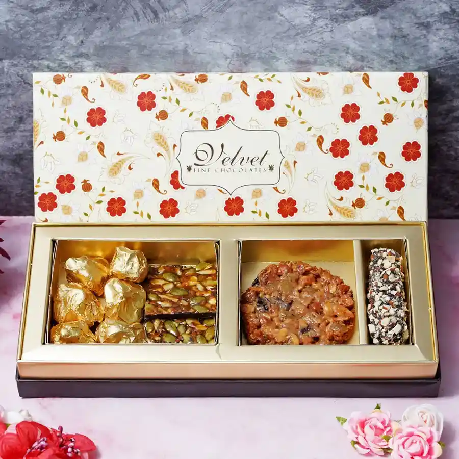 A beautifully arranged gift box filled with crunchy almond rocks, seed squares, a mixed fruit and nut cookie, and an almond finger, perfect for Mother's Day.