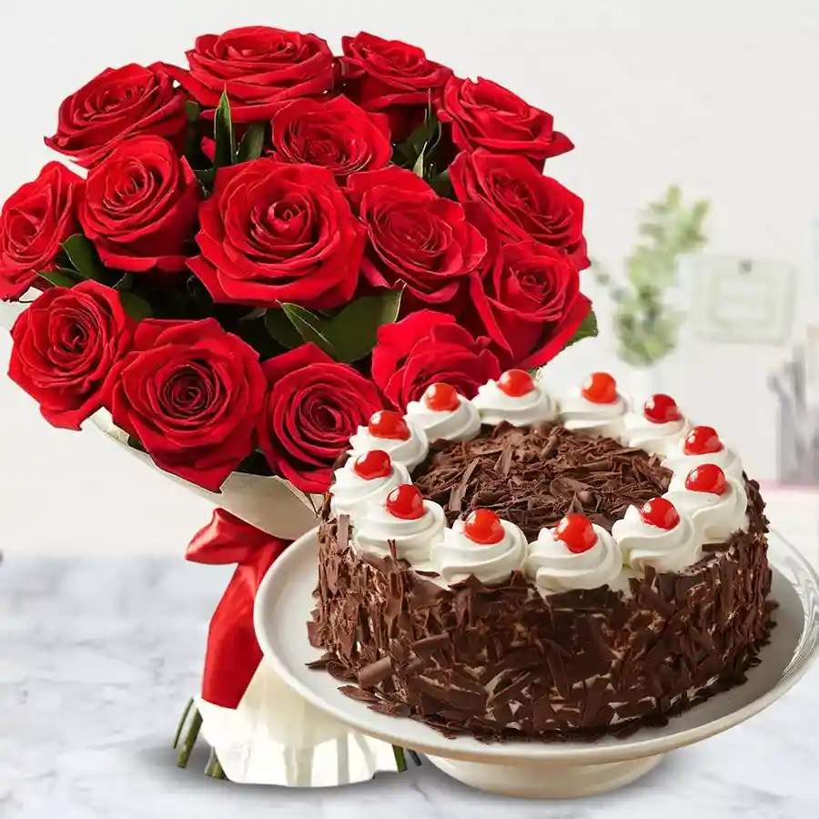 A vibrant bouquet of 12 red roses beside a delicious 1kg Black Forest cake, perfect for celebrating special moments.
