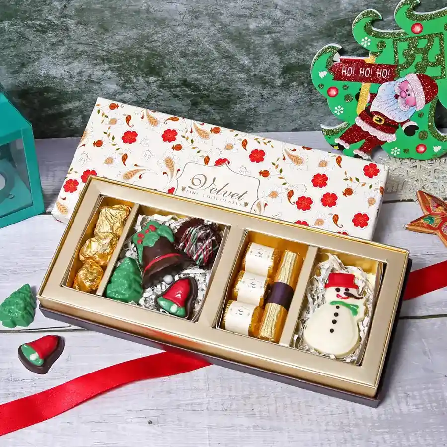 Christmas Chocolates Elegance Gift Box featuring Almond Rocks, Christmas Confections, premium chocolates, a Chocolate Log, and a chocolate Snowman arranged elegantly