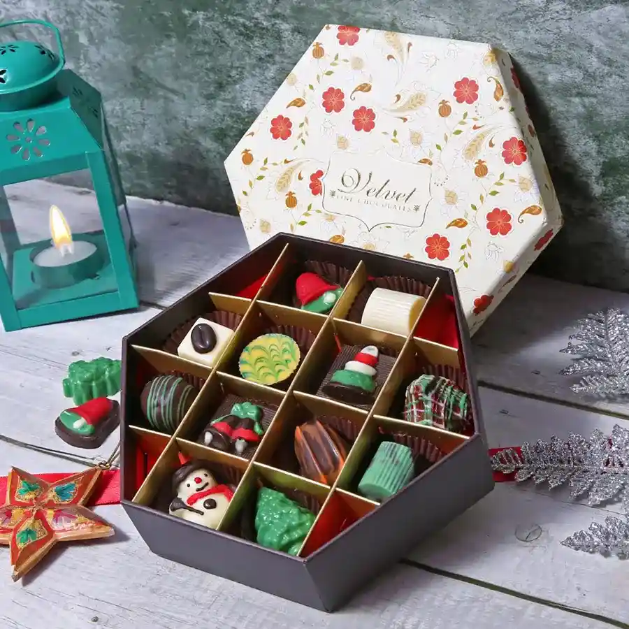 A beautifully arranged box of 12 assorted chocolates with various shapes and colors, perfect for gifting.
