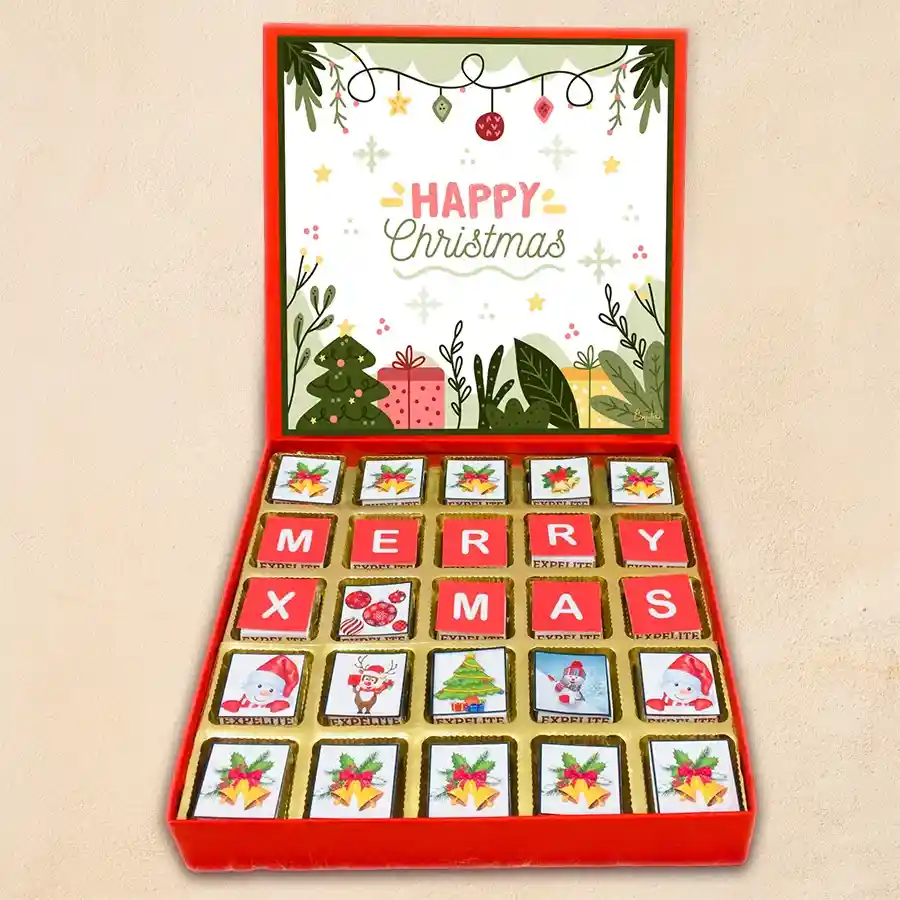 A beautifully arranged gift box filled with 25 festive chocolates in Christmas-themed packaging, featuring a variety of flavors such as roasted dryfruit, cranberry, paan, butterscotch, mixed fruits, and chocochip.