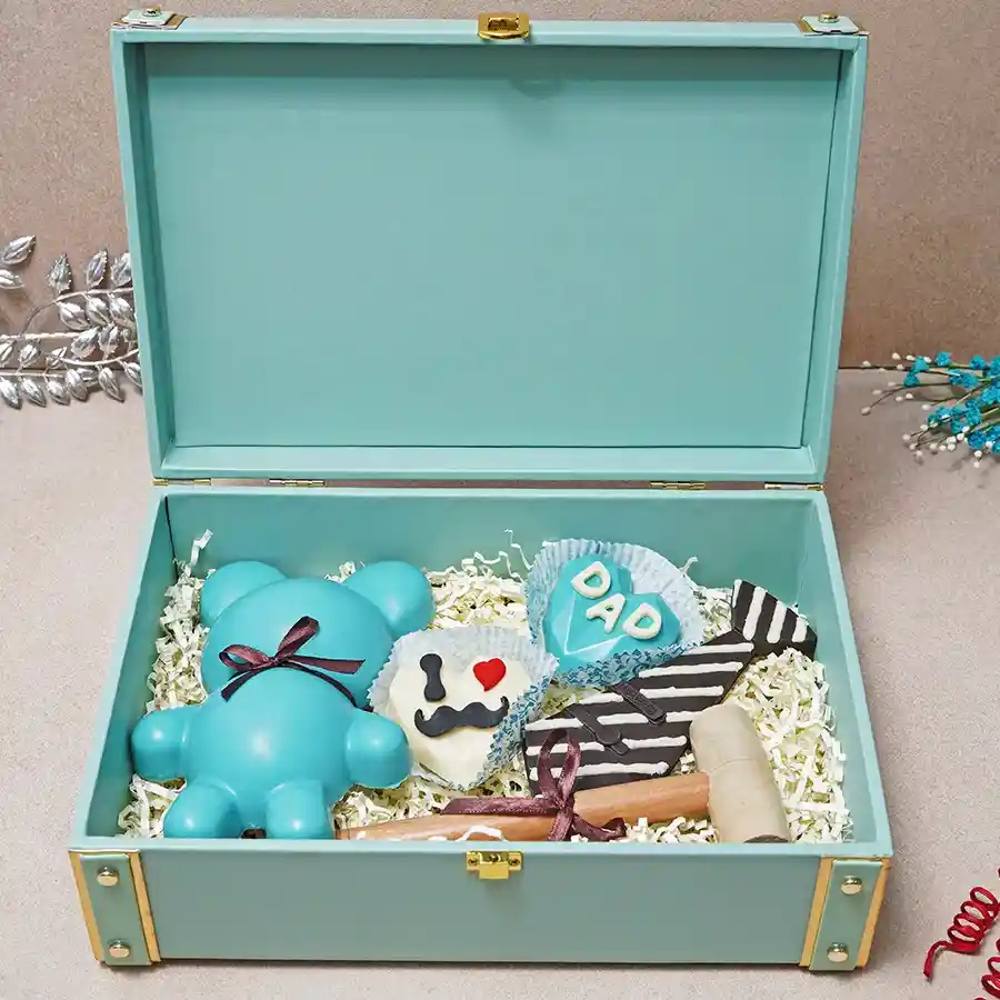 Exciting Choco Treats Trunk filled with a breakable chocolate teddy bear, hot chocolate pinatas, a chocolate tie, and a hammer for cracking open treats