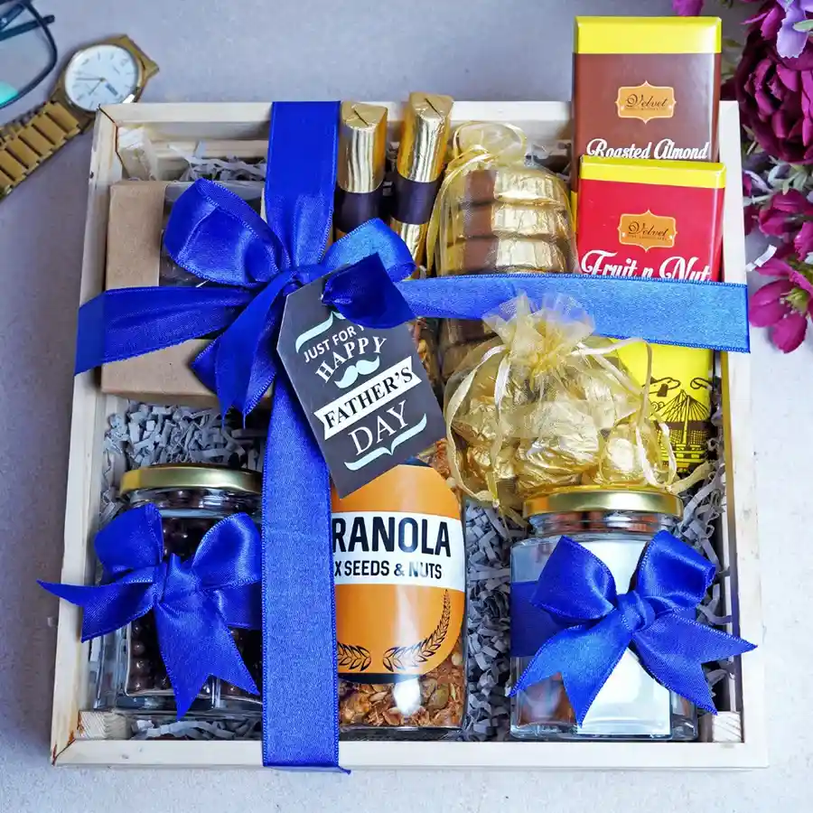 Assorted Chocolates Treats Delight Hamper featuring assorted cookies, chocolate logs, almond florentines, chocolate bars, almond chocolate rocks, chocolate-coated raisins, and almond cranberry granola.