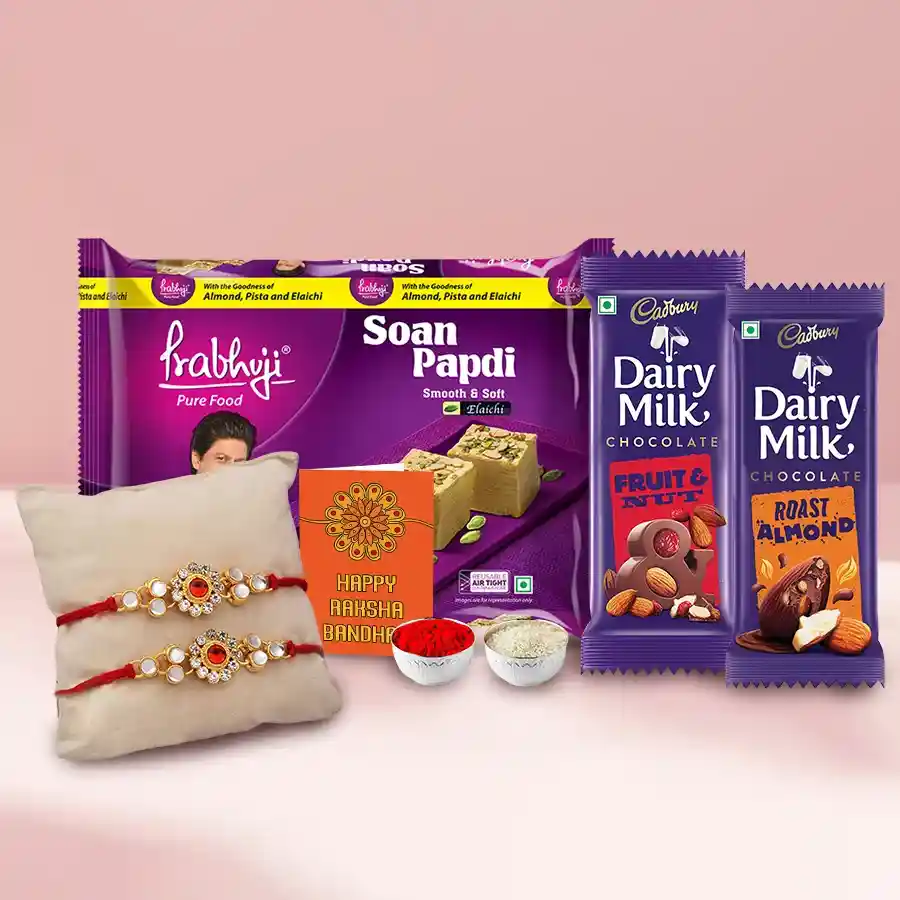 Exquisite festive sweets and chocolate gift hamper with two rakhis, a Rakhi card, and traditional Roli Tilak Chawal