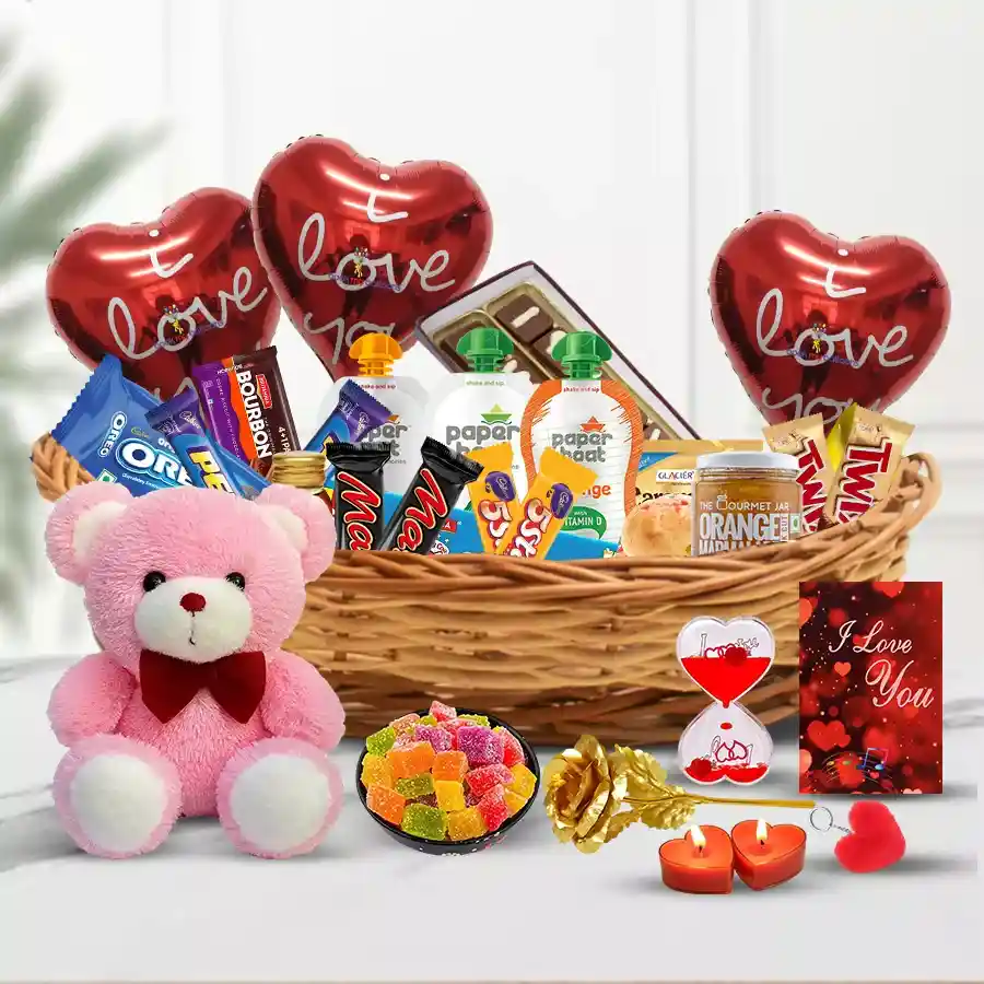 A beautifully arranged Valentine treat basket filled with caramel, Britannia cheese, Oreos, Twix and Mars chocolates, honey, marmalade, a teddy bear, handmade chocolates, love messages, heart-shaped gifts, candles, and balloons.