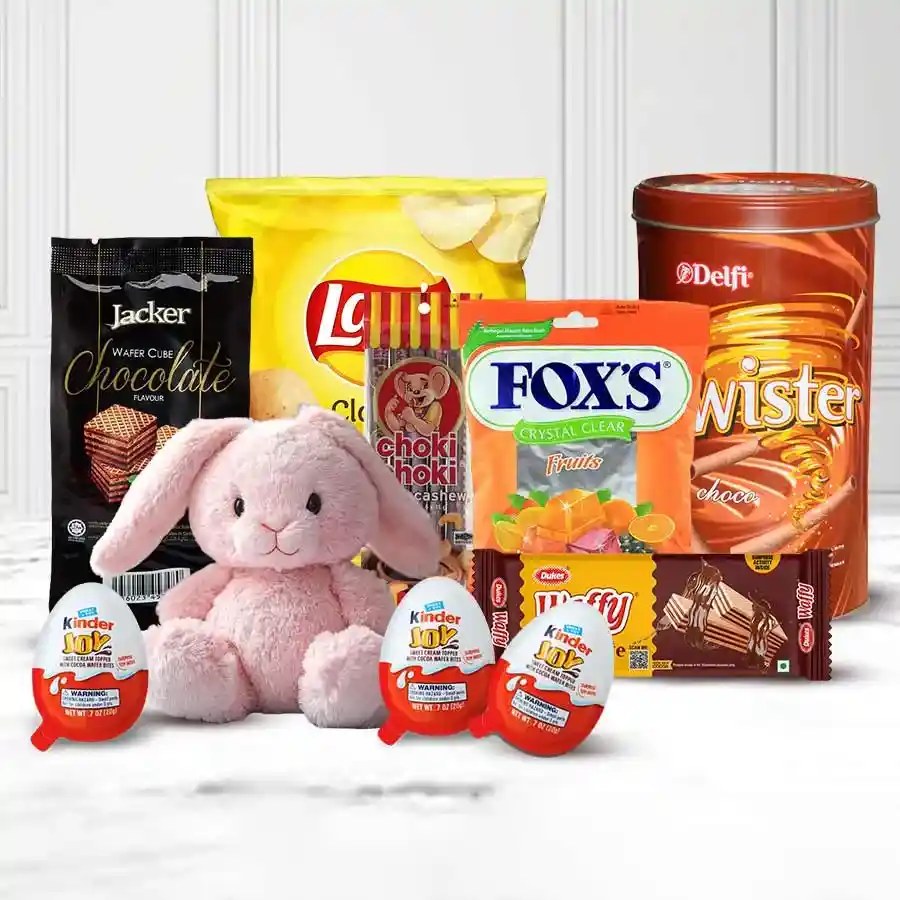 A beautifully arranged hamper filled with assorted chocolates, chips, wafers, and a cute bunny.