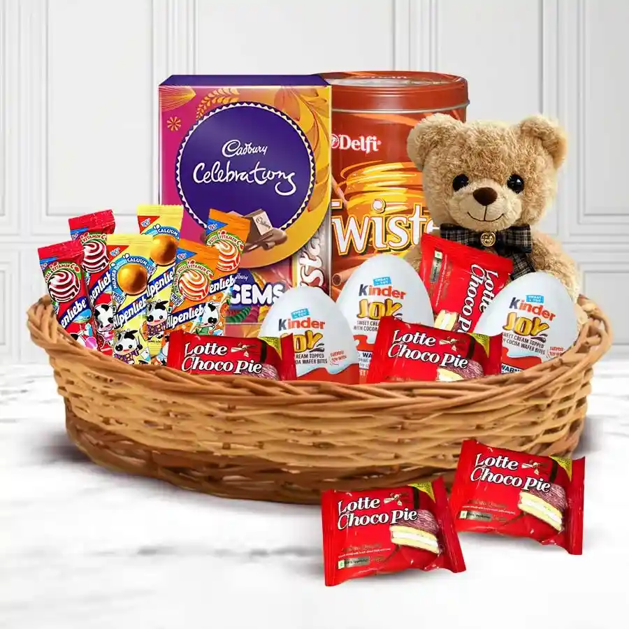 Colorful basket filled with assorted kids chocolates, including Mini Cadbury Celebration, Dukes Twister Choco Wafers, Kinder Joys, Chocopies, Alpenliebe Lollipops, and a cute 6-inch teddy bear.