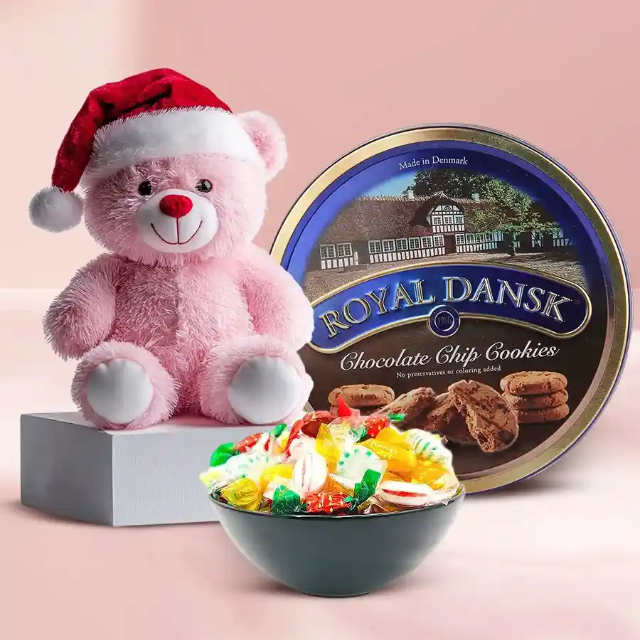 Zesty teddy bear wearing a Santa cap surrounded by a tin of premium Danish chocolates and colorful candies in festive packaging