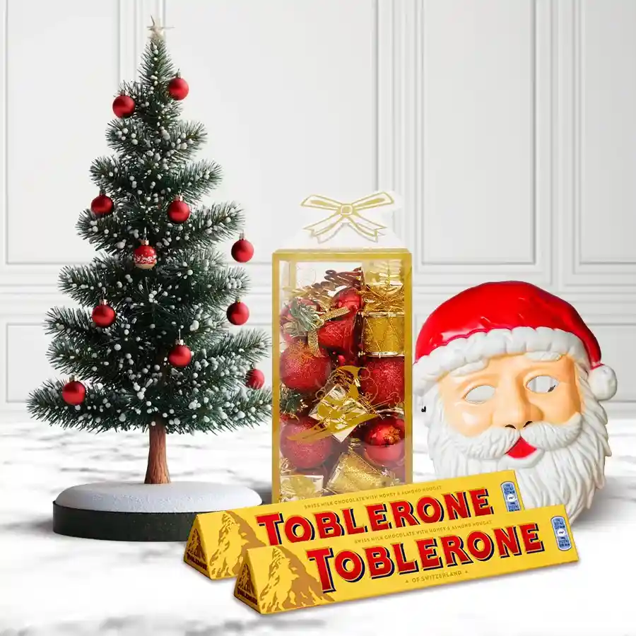 Gift set featuring Toblerone chocolates, a Santa mask, a decorated Christmas tree, and sparkling decorations