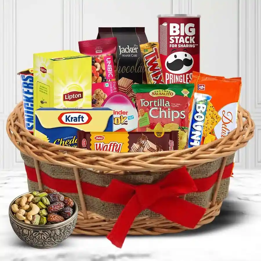 Bliss of Taste Gift Hamper containing Deluxe Cheese Sandwich Crackers, Twix, Snickers, Pringles Chips, UNIBIC Cookies, nuts, Darjeeling Tea, and dry fruits in a decorative container.