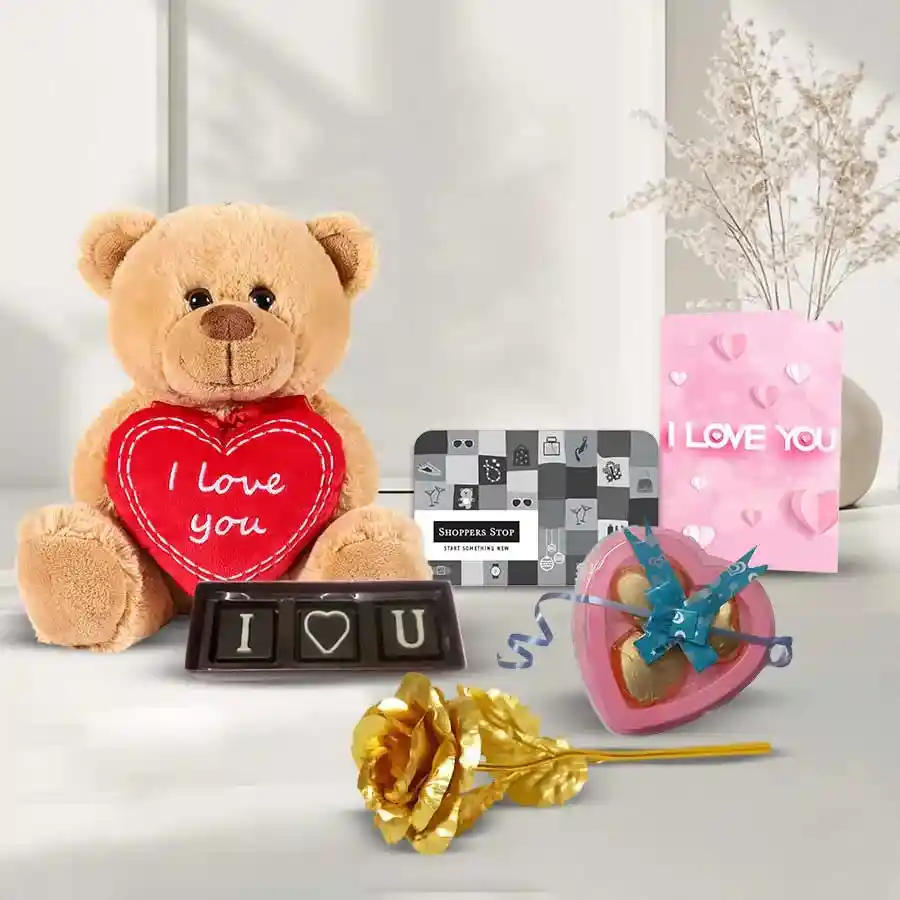 Classic gift hamper featuring a ₹500 Shoppers Stop e-voucher, heart-shaped assorted chocolates, a 25g "I Love You" chocolate, a singing teddy bear, a golden rose, and a heartfelt card