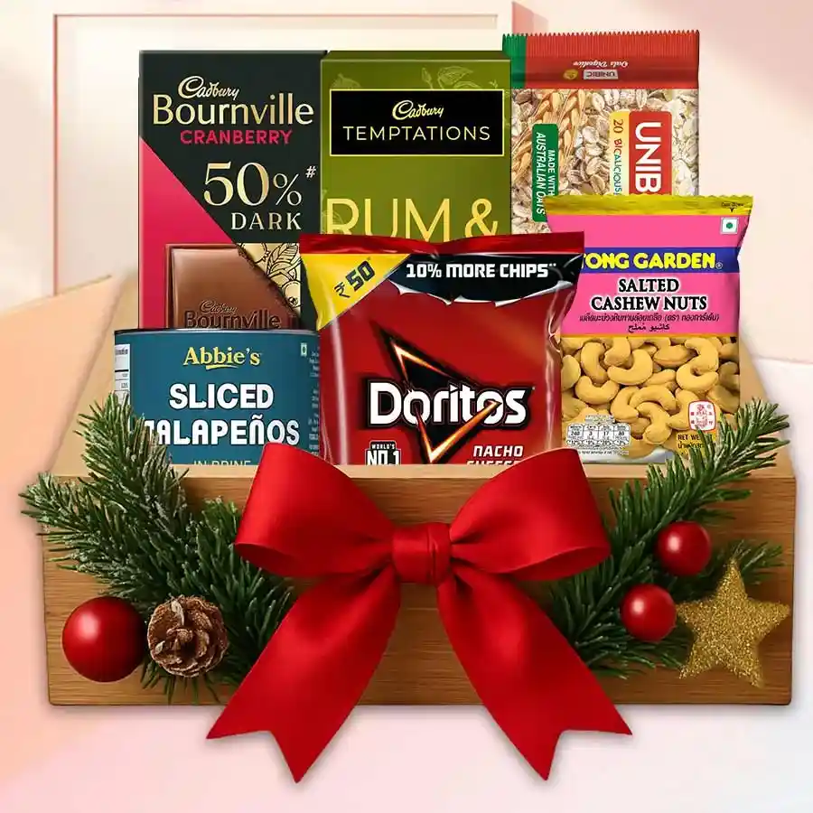 Festive Celebration Gift Basket filled with Doritos Nachos, Cadbury Temptation Rum & Raisins, spicy canned jalapeños, crunchy salted cashews, UNIBIC Oats Cookies, and creamy Cadbury Bourneville, arranged on a medium tray with Christmas accessories.