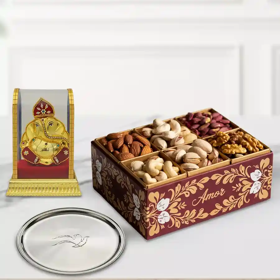 Elegant gift box featuring a silver plated thali, a Vinayak murti, and an assortment of dry fruits including pista, cashews, almonds, and raisins.
