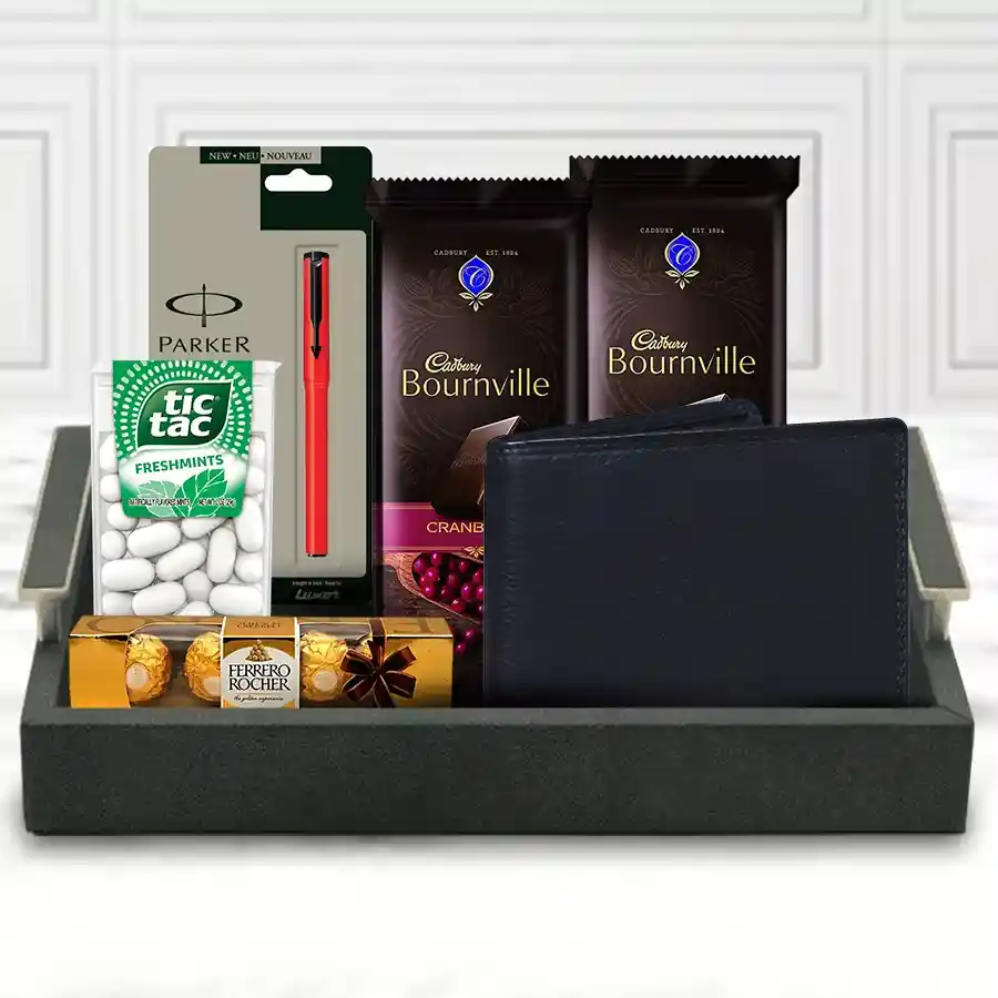 Gift hamper for gents featuring a black leather wallet, a red and black pen, Tic Tacs, Ferrero Rocher chocolates, and Cadbury Bournville chocolates arranged elegantly