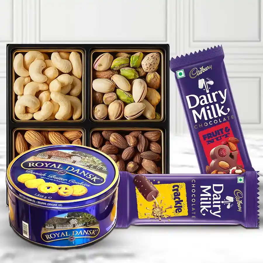 Gift box filled with cookies, chocolates, and dry fruits including Cadbury Dairy Milk bars, Danish cookies, almonds, pistachios, cashews, and raisins.