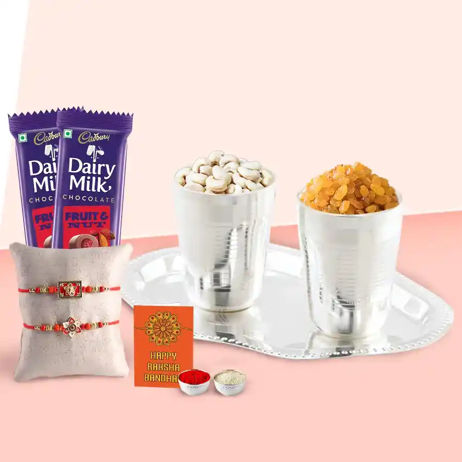 Delicious Dry Fruits Hamper featuring silver plated glasses and tray, assorted dry fruits, two Cadbury Dairy Milk Fruit & Nut bars, designer rakhis, and a personalized message card