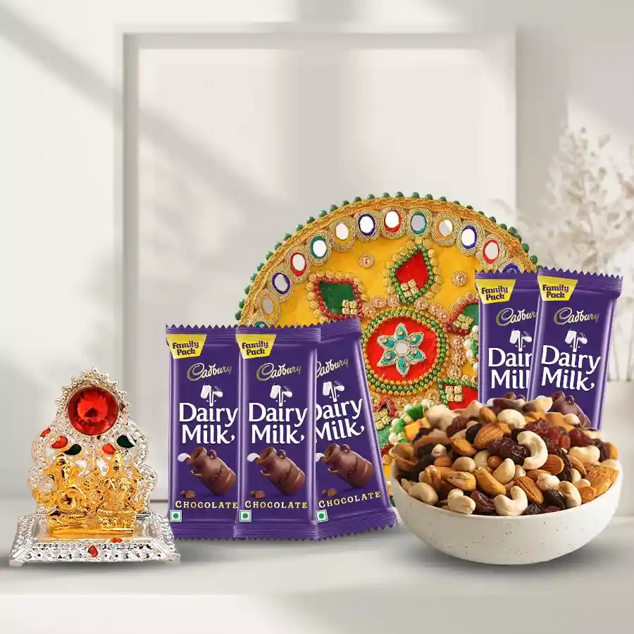 Assorted dry fruits including almonds, raisins, cashews, walnuts, Cadbury Dairy Milk chocolates, and a beautifully decorated Ganesh and Laxmi Mandap Pooja Thali arranged as a festive gift.