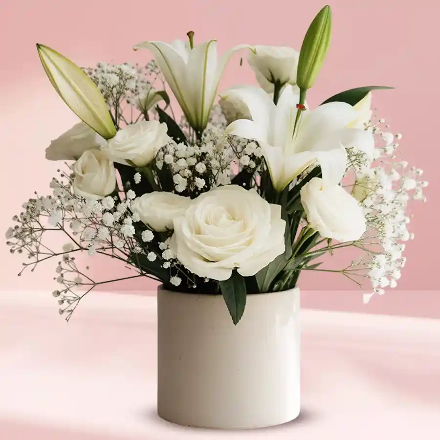 Elegant white floral arrangement in a ceramic pot, showcasing a mix of stunning white flowers.