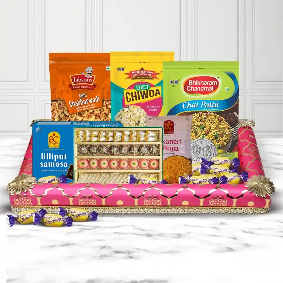 Bhikarams Diwali Hamper featuring assorted treats, designer diyas, a silver-plated coin, and a decorated tray