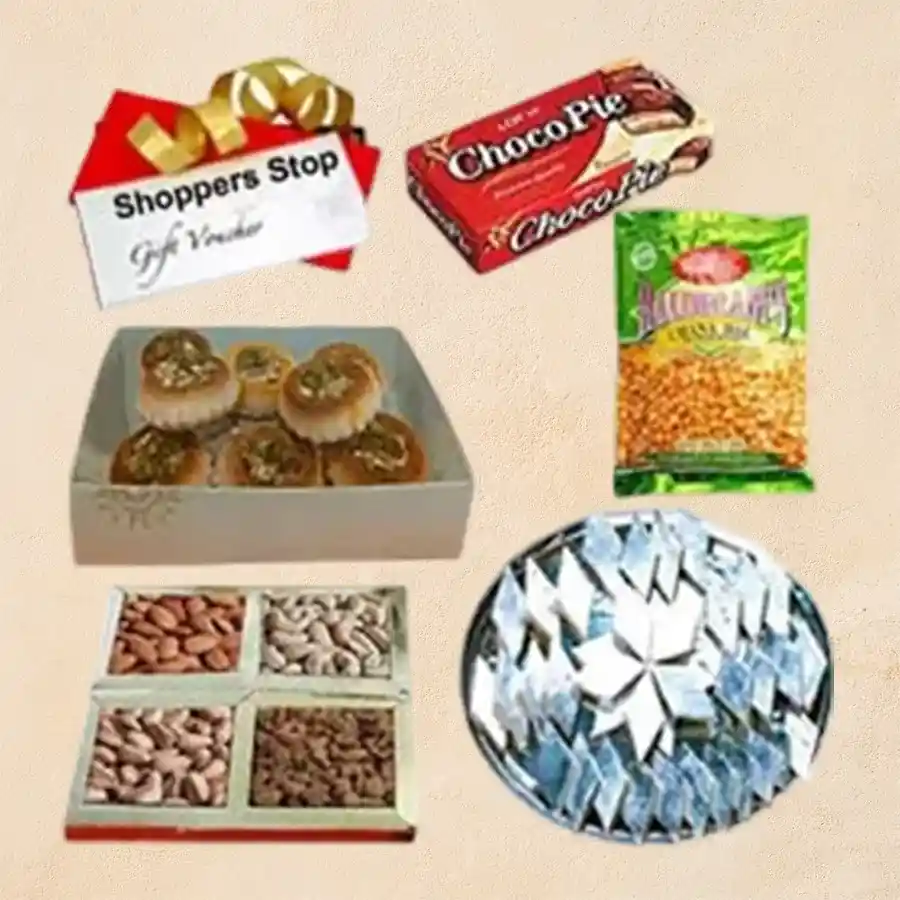 Gift box featuring assorted dry fruits, Kaju Katli, Badam Baked Kalash, Chana Dal, Chocopie, and a Shoppers Stop Gift E Voucher.