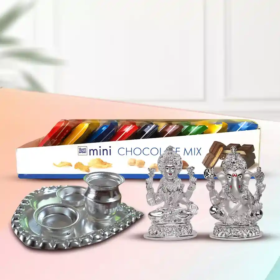 Elegant gift hamper featuring 9 Ritter Sport Mini Imported Chocolates, a silver-plated Ganesh Laxmi idol, and a sleek paan-shaped silver pooja thali.