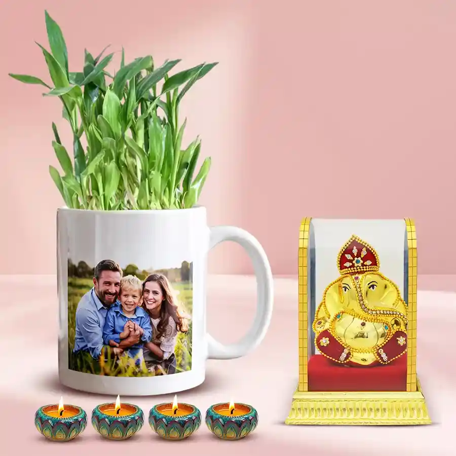 Prayerful Vighnesh Ganesh Idol with personalized photo mug, 2-tier Lucky Bamboo plant, and Designer Wax Diya on a festive background