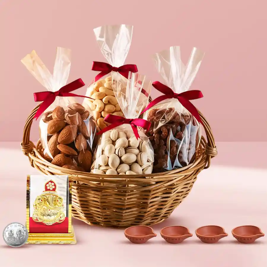 Delightful basket of premium dry fruits including pistachios, almonds, raisins, and cashews, accompanied by a Vighnesh Ganesh idol, four decorative earthen diyas, and a silver-plated Laxmi Ganesh coin, all set for Diwali celebrations.