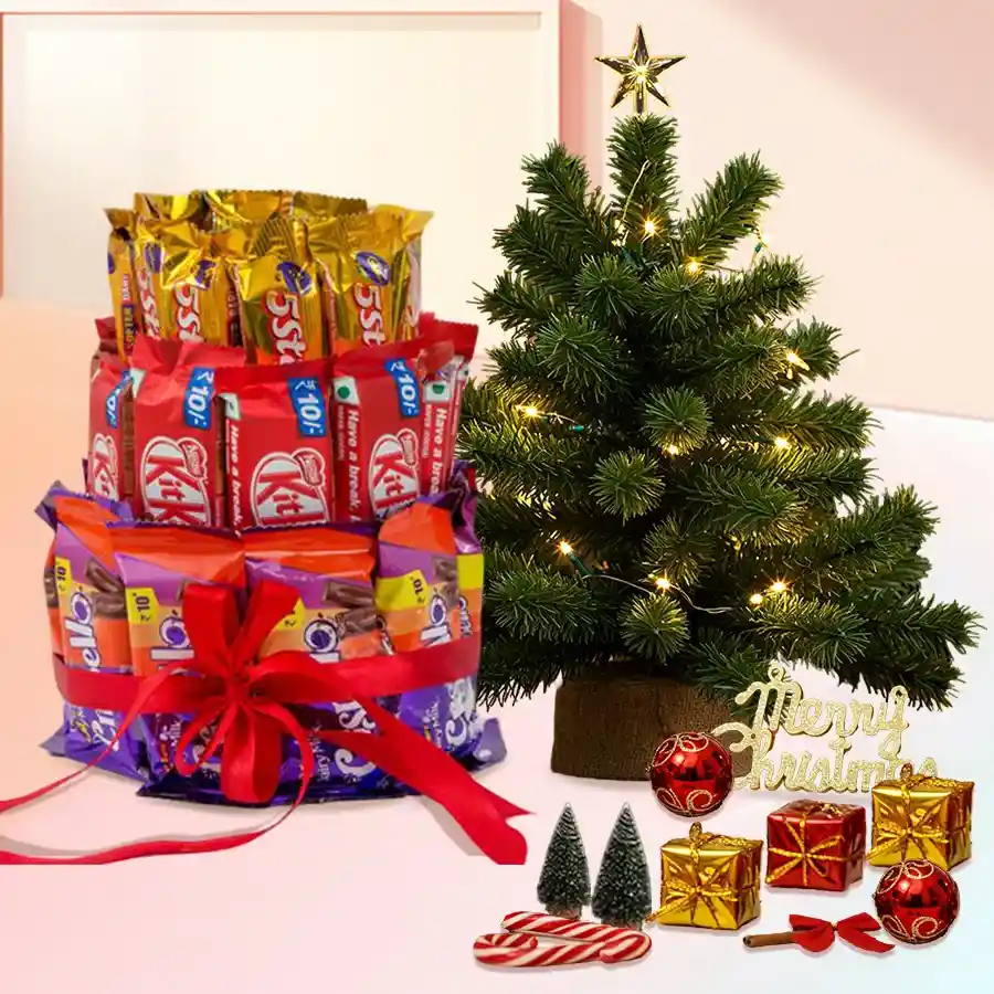 Three-layer chocolate arrangement featuring Nestle KitKats, Cadbury 5 Stars, and Cadbury Crispellos, adorned with a festive red ribbon and accompanied by a small Christmas tree and decorations.