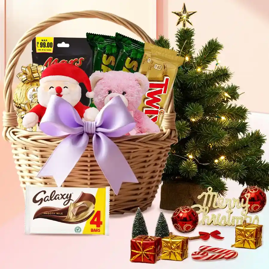 Exclusive Chocolate Gift Basket featuring Ferrero Rocher, Twix, Mars Miniatures, Galaxy bar, a 6-inch teddy bear, a Santa Claus soft toy, a 1-ft Christmas tree, and decorations, all arranged in a stylish basket with a bow.