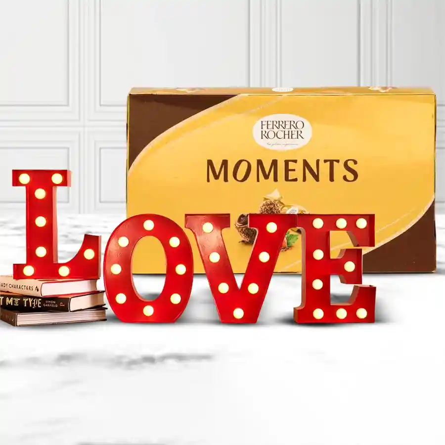 A beautifully arranged gift set featuring 16 Ferrero Rocher Moments chocolates and a red Love Lamp, symbolizing romance and affection for Valentine's Day.