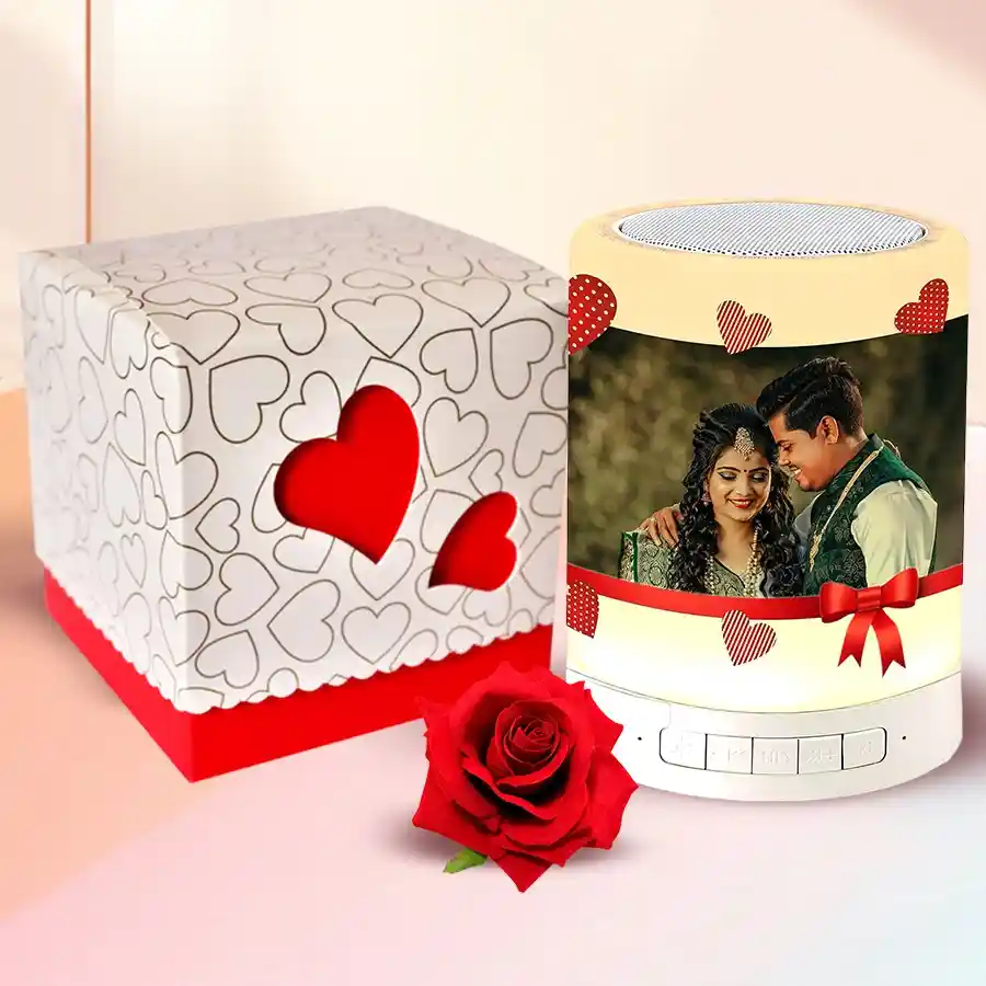 Personalized Bluetooth speaker with a photo, heart-shaped chocolate box, and red velvet rose for Valentine's Day gift combo
